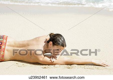 View of a topless woman lying on a beach. View Large Photo Image Stock Image - View of a topless woman lying on a beach.. Fotosearch