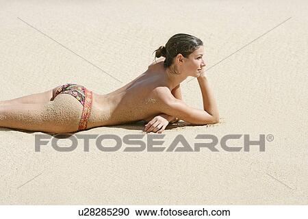 View of a topless woman lying on a beach. View Large Photo Image Stock Image - View of a topless woman lying on a beach.. Fotosearch