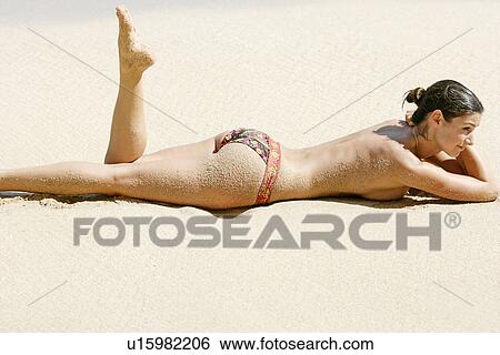 View of a topless woman lying on a beach. View Large Photo Image Stock Photograph - View of a topless woman lying on a beach.. Fotosearch