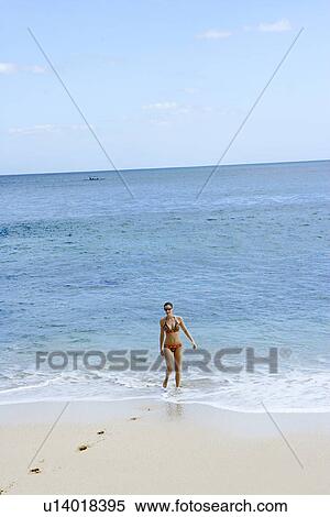 Stock Photography - View of a woman standing on a beach.. Fotosearch
