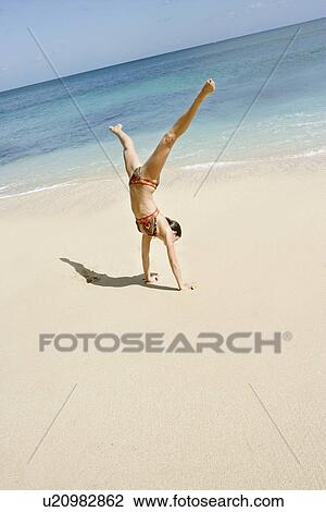 Stock Image - View of woman performing acrobatic feat.. Fotosearch