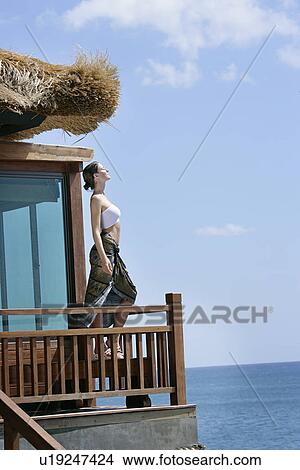 Picture - A woman standing in a balcony.. Fotosearch