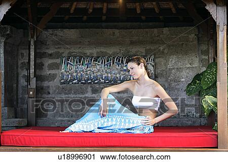 A young woman lying on red cushion. View Large Photo Image Stock Image - A young woman lying on red cushion.. Fotosearch