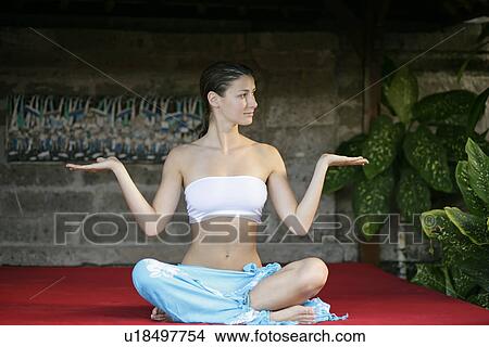 A young woman sitting on red cushion. View Large Photo Image Picture - A young woman sitting on red cushion.. Fotosearch