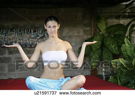 A young woman sitting on red cushion. View Large Photo Image Stock Photo - A young woman sitting on red cushion.. Fotosearch
