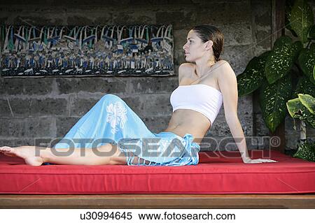 A young woman sitting on red cushion. View Large Photo Image Stock Photography - A young woman sitting on red cushion.. Fotosearch