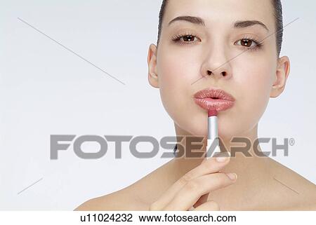 Close-up of a young woman applying lip stick. View Large Photo Image Stock Image - Close-up of a young woman applying lip stick.. Fotosearch