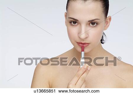 Close-up of a young woman applying lipstick. View Large Photo Image Stock Image - Close-up of a young woman applying lipstick.. Fotosearch