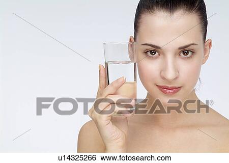 Close-up of a young woman holding glass of water. View Large Photo Image Stock Photograph - Close-up of a young woman holding glass of water.. Fotosearch
