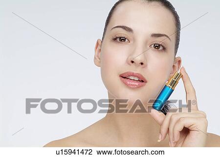 Close-up of a young woman holding lipstick. View Large Photo Image Stock Image - Close-up of a young woman holding lipstick.. Fotosearch