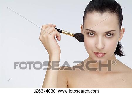 Close-up of a young woman holding makeup brush in hand. View Large Photo Image Stock Image - Close-up of a young woman holding makeup brush in hand.. Fotosearch
