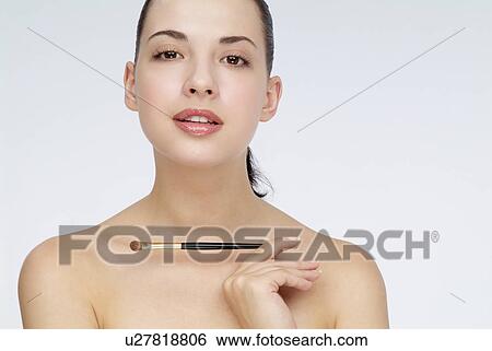 Close-up of a young woman holding makeup brush. View Large Photo Image Stock Photograph - Close-up of a young woman holding makeup brush.. Fotosearch