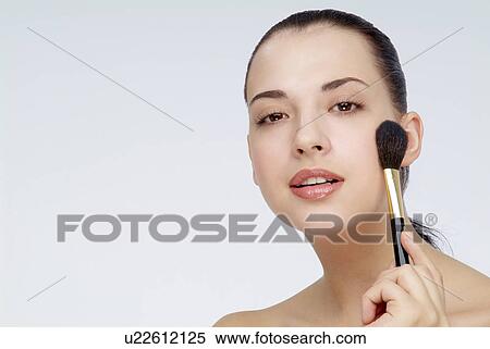 Close-up of a young woman holding makeup brush. View Large Photo Image Stock Photography - Close-up of a young woman holding makeup brush.. Fotosearch