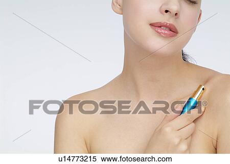 Stock Photography - View of a woman holding lipstick.. Fotosearch