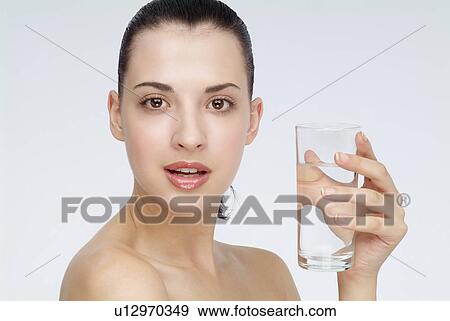 Stock Photo - View of a young woman holding glass of water.. Fotosearch