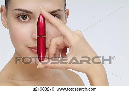 View of a young woman holding lipstick. View Large Photo Image Stock Photograph - View of a young woman holding lipstick.. Fotosearch