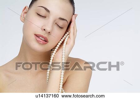 View of a young woman holding pearl necklace. View Large Photo Image Stock Image - View of a young woman holding pearl necklace.. Fotosearch