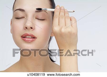 View of a young woman using eyebrow pencil. View Large Photo Image Stock Photo - View of a young woman using eyebrow pencil.. Fotosearch