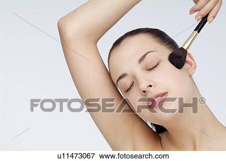 View of a young woman using foundation brush. View Large Photo Image Stock Photo - View of a young woman using foundation brush.. Fotosearch