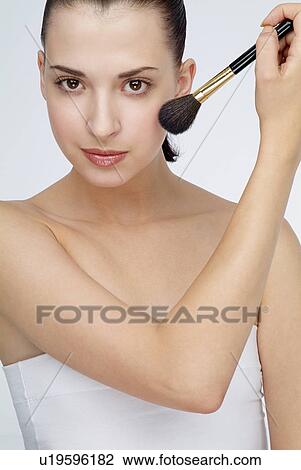 Close-up of a young woman holding makeup brush. View Large Photo Image Stock Image - Close-up of a young woman holding makeup brush.. Fotosearch