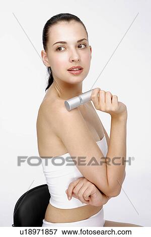 Stock Photo - Close-up of a young woman holding deodorant.. Fotosearch