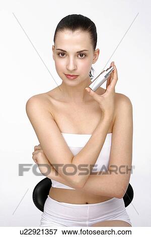 Close-up of a young woman holding deodorant. View Large Photo Image Stock Photo - Close-up of a young woman holding deodorant.. Fotosearch