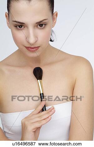 View of a young woman holding makeup brush. View Large Photo Image Stock Photo - View of a young woman holding makeup brush.. Fotosearch