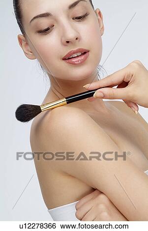 View of a young woman holding makeup brush. View Large Photo Image Stock Photograph - View of a young woman holding makeup brush.. Fotosearch