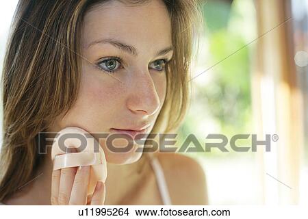 A woman applying makeup. View Large Photo Image Picture - A woman applying makeup.. Fotosearch