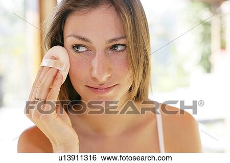 Stock Photograph - A woman applying makeup.. Fotosearch