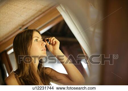 Picture - A woman applying mascara.. Fotosearch