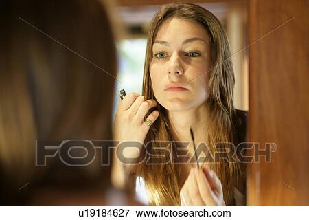 A woman doing makeup. View Large Photo Image Stock Photo - A woman doing makeup.. Fotosearch