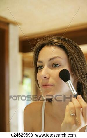 Stock Photo - A woman doing makeup.. Fotosearch