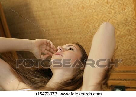 Stock Image - A woman handling her hair.. Fotosearch