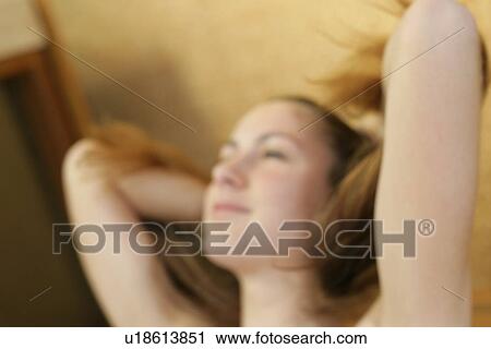 Stock Image - A woman handling her hair.. Fotosearch