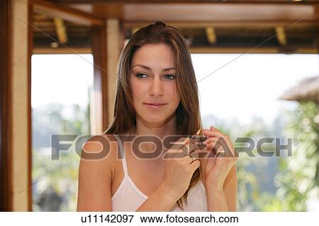 Stock Photo - A woman holding perfume bottle.. Fotosearch