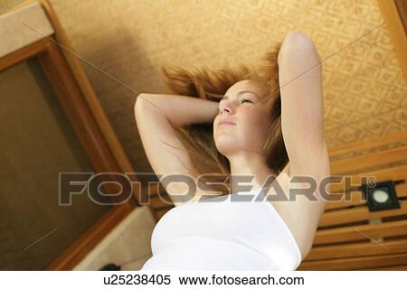 Stock Photography - Low angle view of a woman holding her hair.. Fotosearch