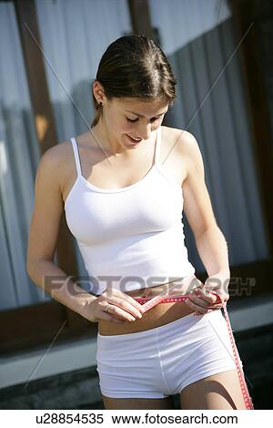 View of a young woman measuring her tummy. View Large Photo Image Stock Photography - View of a young woman measuring her tummy.. Fotosearch