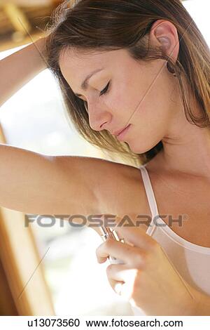 Stock Image - Woman spraying a perfume.. Fotosearch