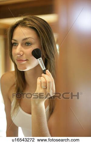Young woman applying blusher on cheeks. View Large Photo Image Stock Image - Young woman applying blusher on cheeks.. Fotosearch