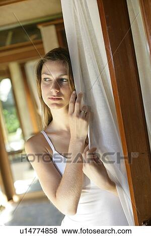 Young woman holding white curtain near door. View Large Photo Image Stock Photo - Young woman holding white curtain near door.. Fotosearch