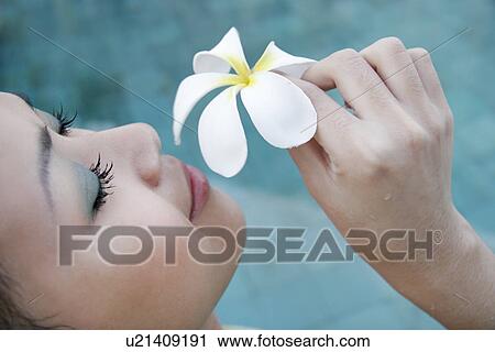 Stock Image - A teenage girl holding a flower.. Fotosearch