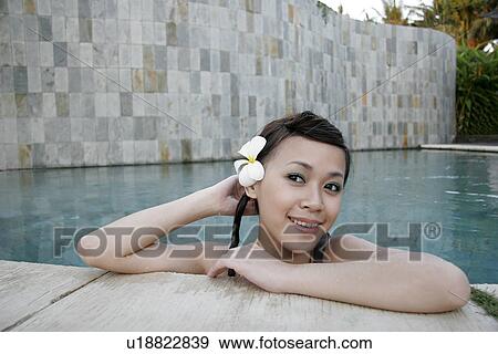 Stock Photo - A teenage girl leaning near swimming pool.. Fotosearch