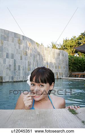 Stock Image - Portrait of a teenage girl in a swimming pool.. Fotosearch