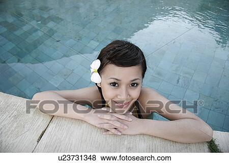 Stock Photo - Portrait of a teenage girl leaning by a swimming pool.. Fotosearch