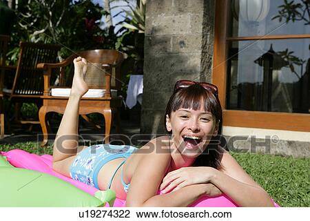 Portrait of a teenage girl lying in garden on a float. View Large Photo Image Stock Image - Portrait of a teenage girl lying in garden on a float.. Fotosearch