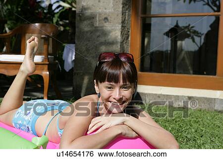 Portrait of a teenage girl lying on float in lawn. View Large Photo Image Stock Photograph - Portrait of a teenage girl lying on float in lawn.. Fotosearch