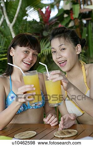Stock Photo - Portrait of teenage girls having juice.. Fotosearch