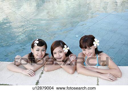 Portrait of three teenage girls leaning by a swimming pool. View Large Photo Image Picture - Portrait of three teenage girls leaning by a swimming pool.. Fotosearch