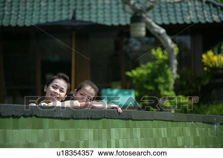 Two teenage girls leaning near boundary wall. View Large Photo Image Stock Photo - Two teenage girls leaning near boundary wall.. Fotosearch